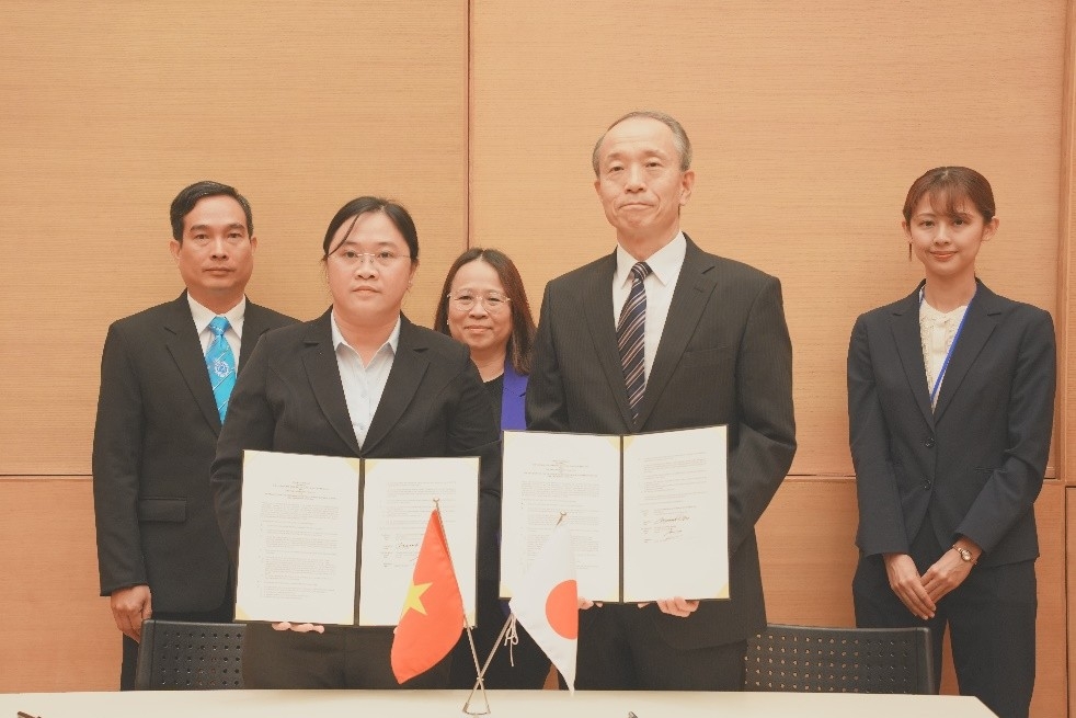 　　贈与契約書を掲げる小野総領事（右）と　フイン・ティー・ホン・ニュン　チャーヴィン大学病院　院長（左）